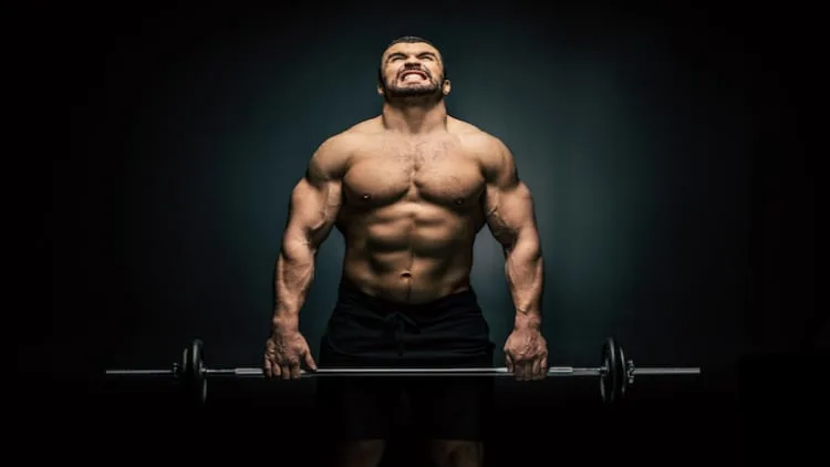 Athletic man gripping onto a heavy barbell