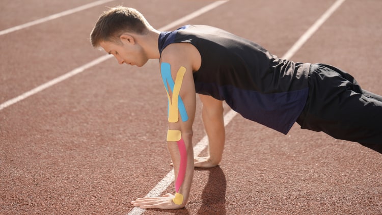 Man doing push up training with physio tape on his arm