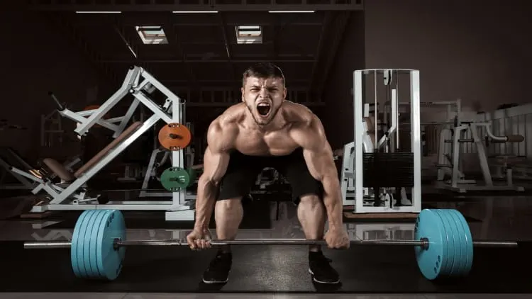 Strong man performing heavy deadlifts with a barbell