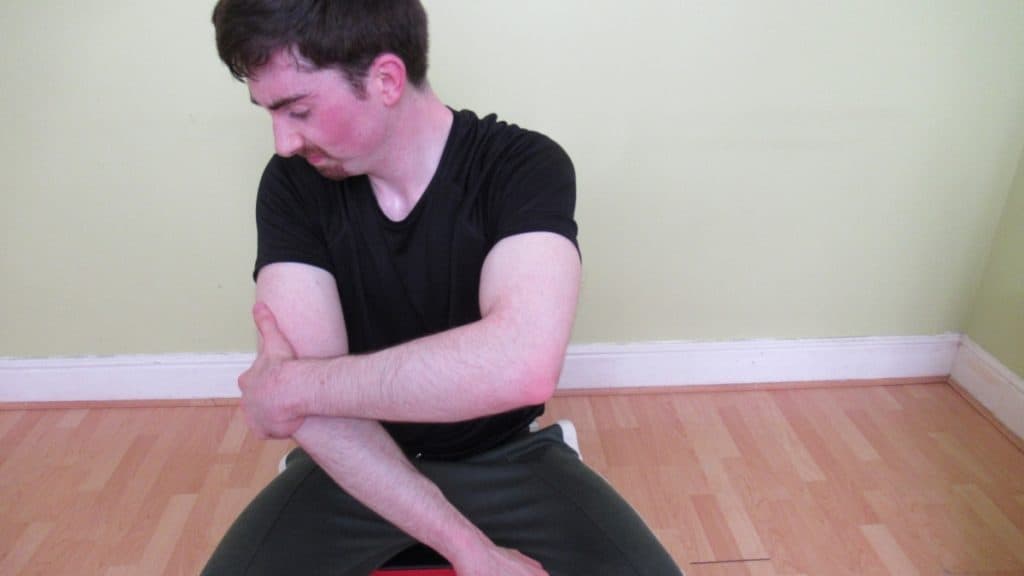 A man with elbow pain after his tricep workout