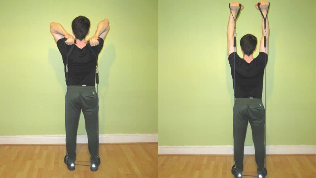 A man doing a French press with resistance bands during his workout