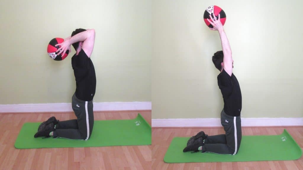 A man doing a kneeling med ball French press