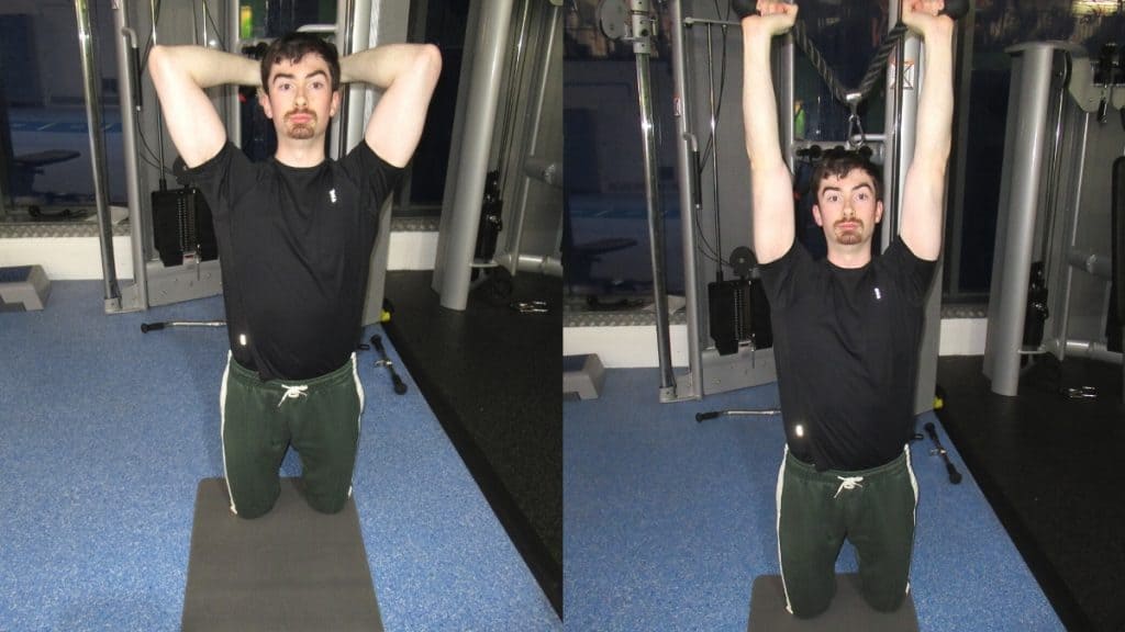 A man performing a kneeling overhead cable tricep extension at the gym