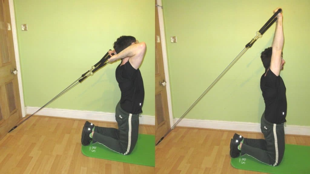 A man doing a kneeling resistance band French press