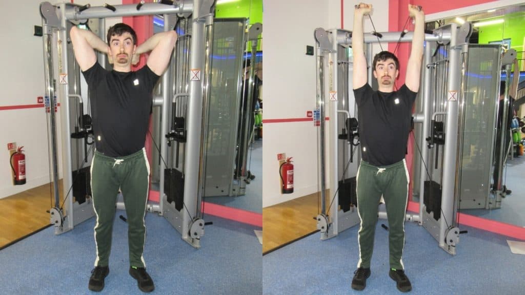 A man performing overhead cable extensions for his triceps at the gym