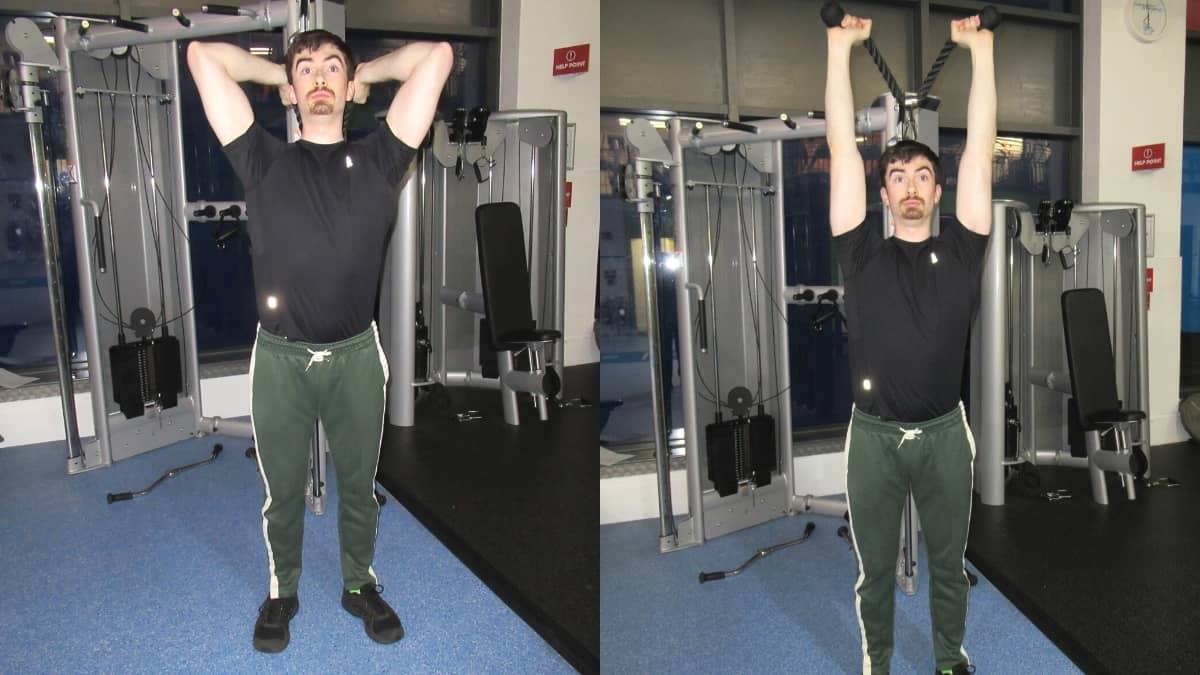 A man doing an overhead rope tricep extension at the gym using cables