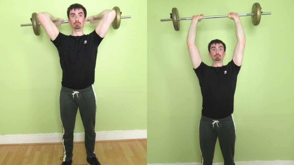 A man performing an overhead standing barbell tricep extension during his workout