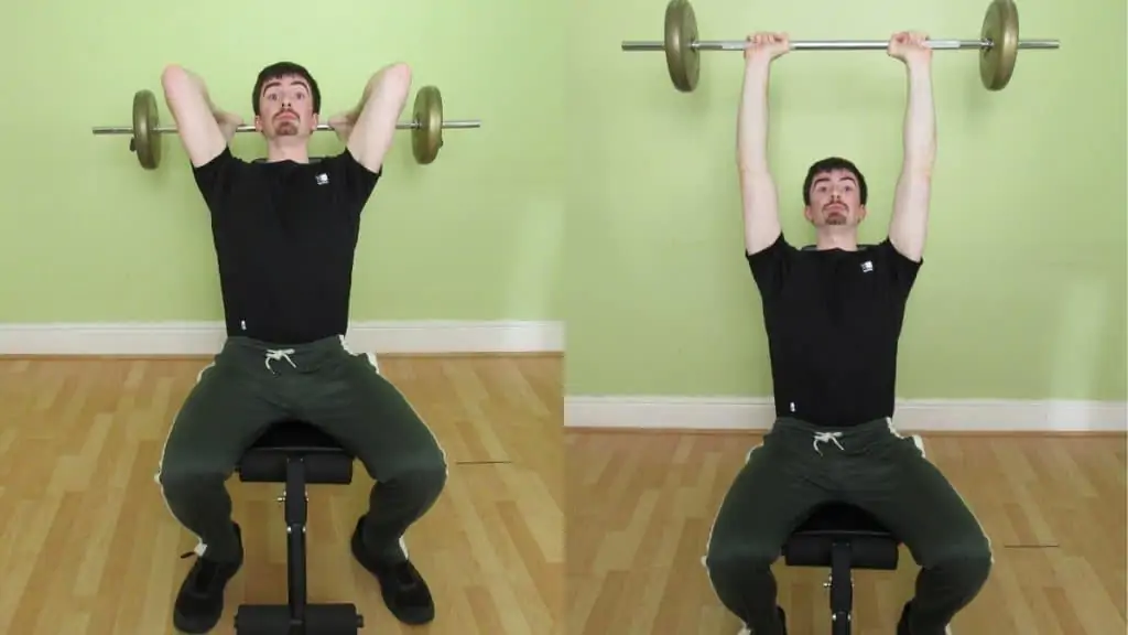 A man performing a seated barbell extension for his triceps