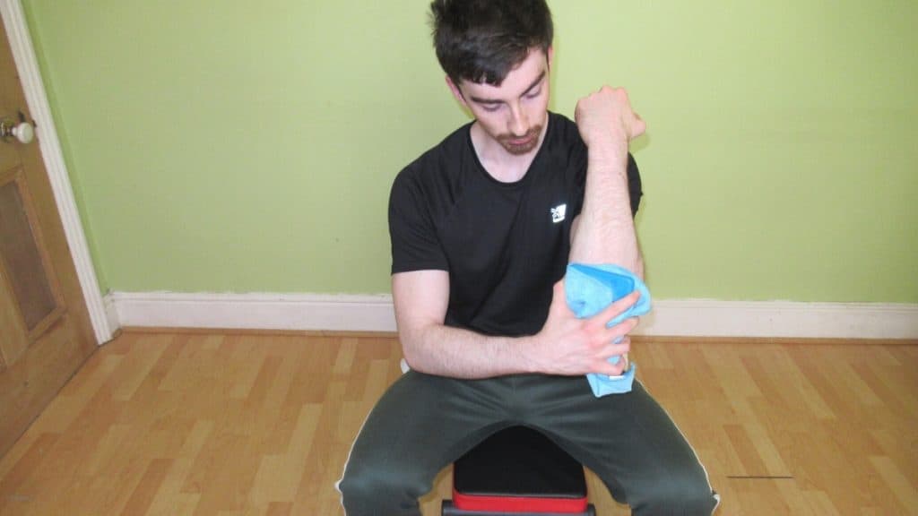 A man holding an ice pack on his elbow