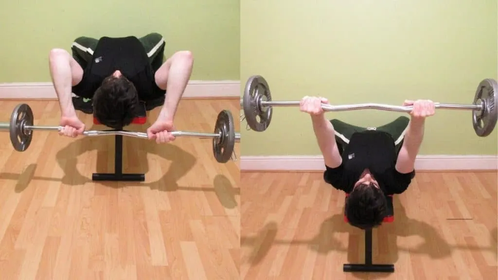 A man doing EZ bar lying triceps extensions on a flat bench