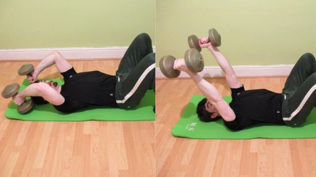 A man performing a floor tricep extension with dumbbells