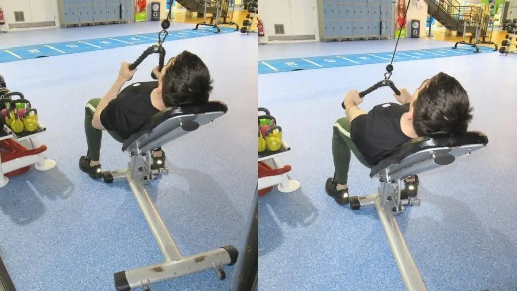 A man performing incline bench tricep pressdowns