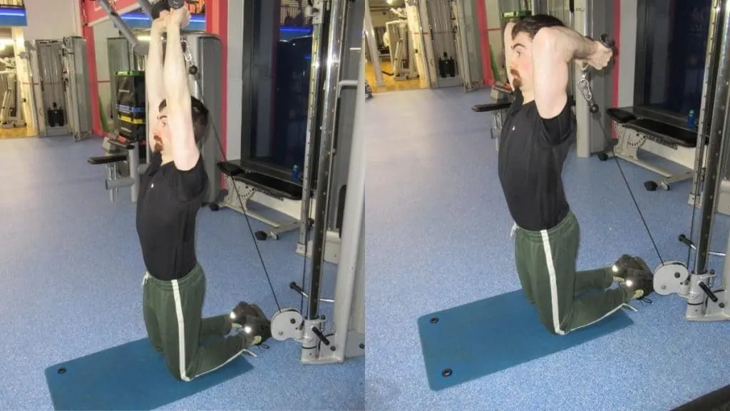 A man performing a kneeling v-bar overhead extension for his triceps