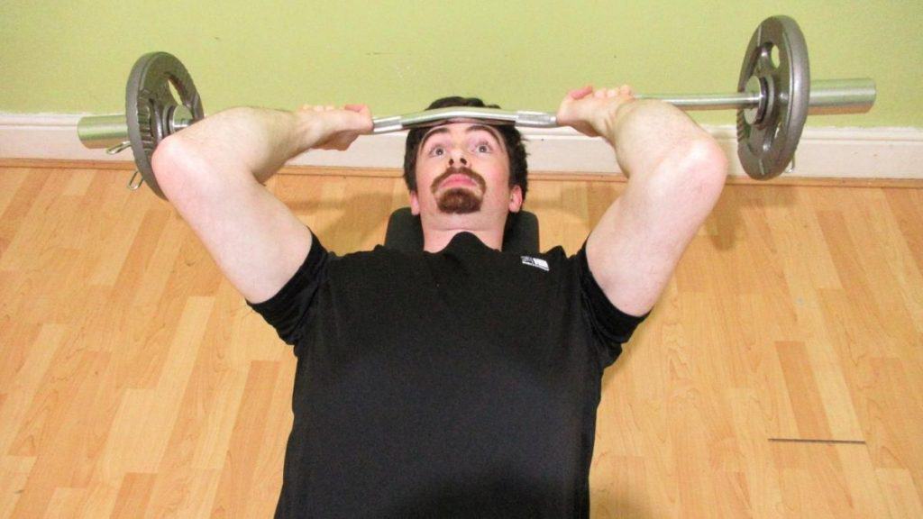 A man doing a skull crusher exercise to train his triceps