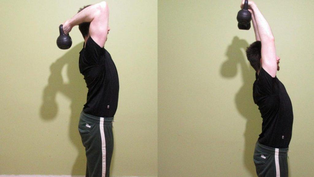 A man performing standing kettlebell tricep extensions
