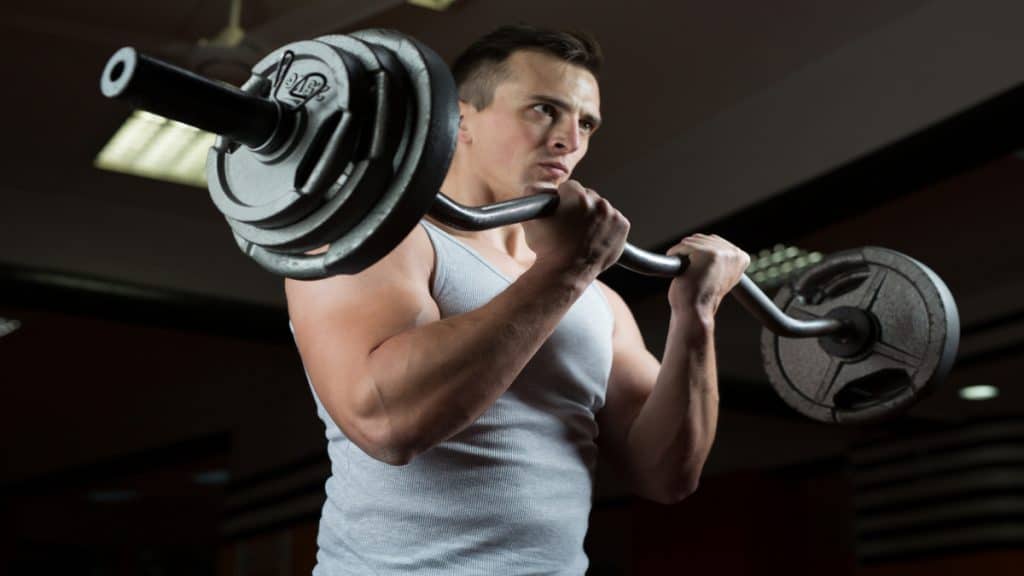 A muscular man doing a 100 lb curl for his biceps
