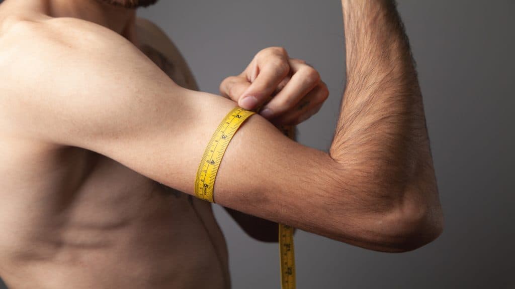 A man measuring his 12 in biceps