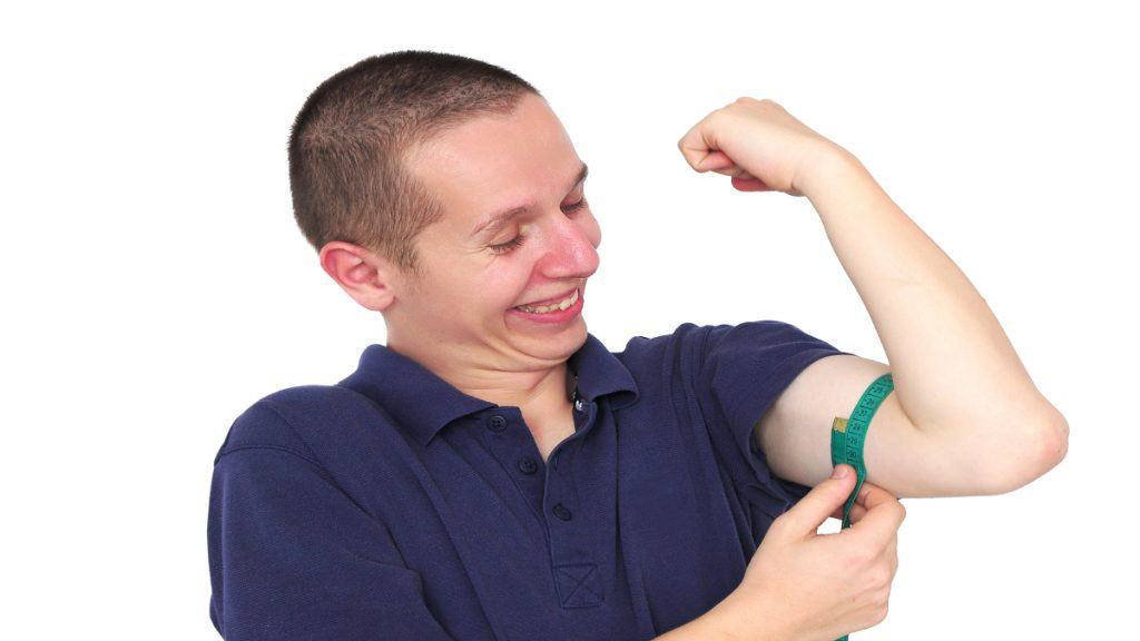 A man looking at his 12 inch arms