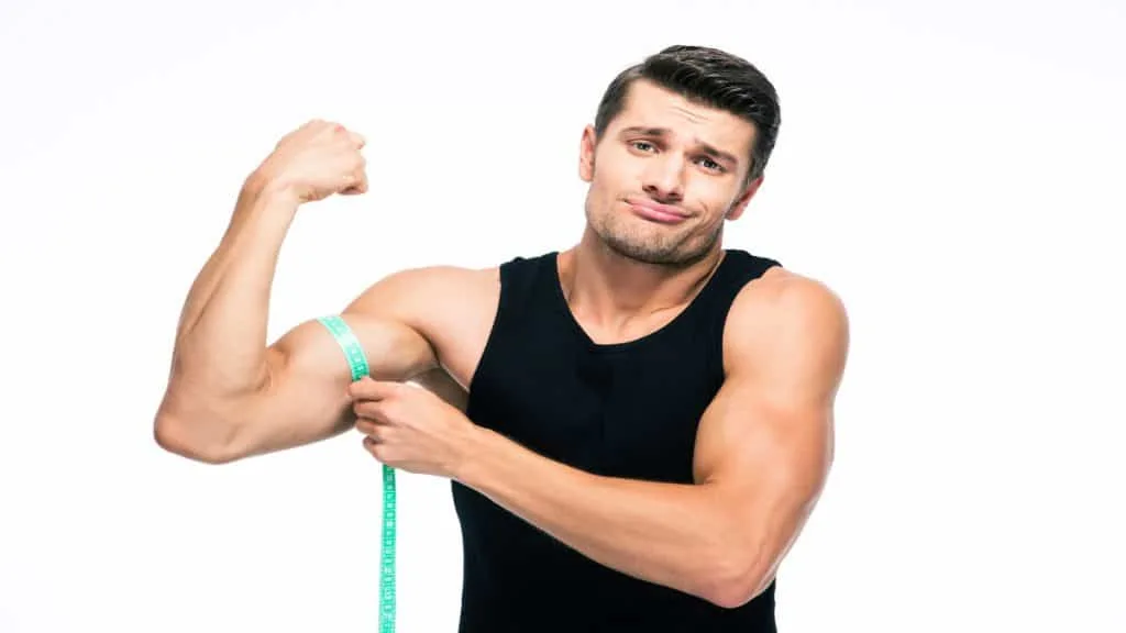 A muscular man flexing his 14.5 inch biceps