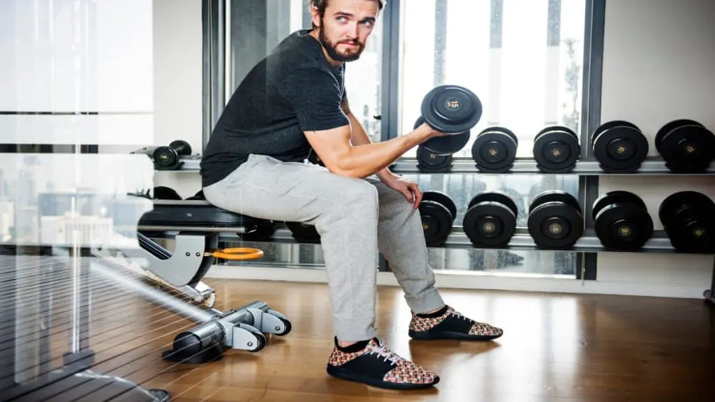 A man performing a 15 lb bicep curl with a dumbbell