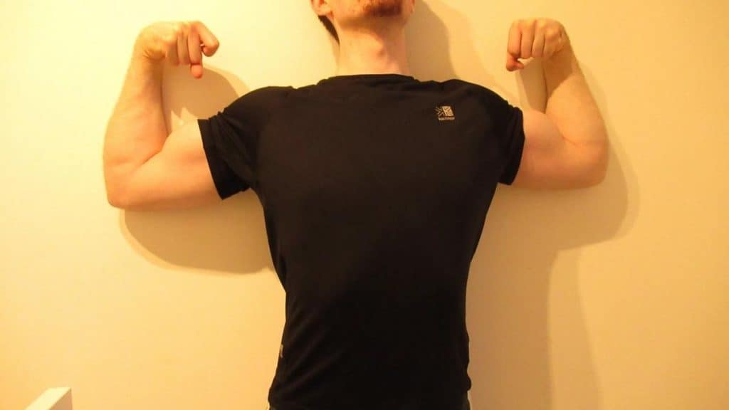 A man flexing his 15.5 inch biceps