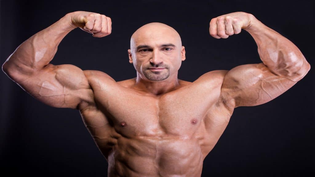 A man flexing his 19.5 inch biceps