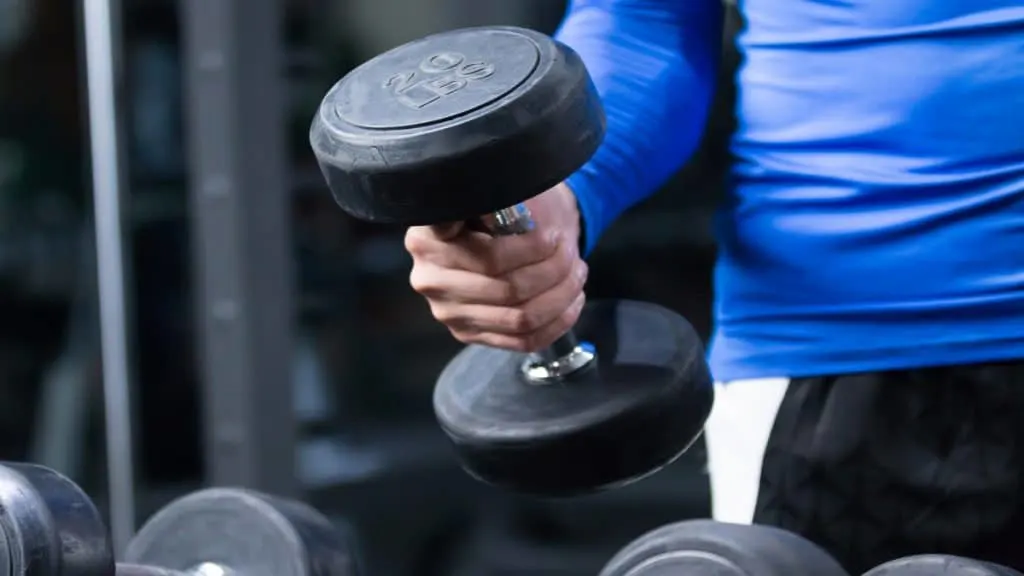 A man performing a 20 lb dumbbell curl for his biceps