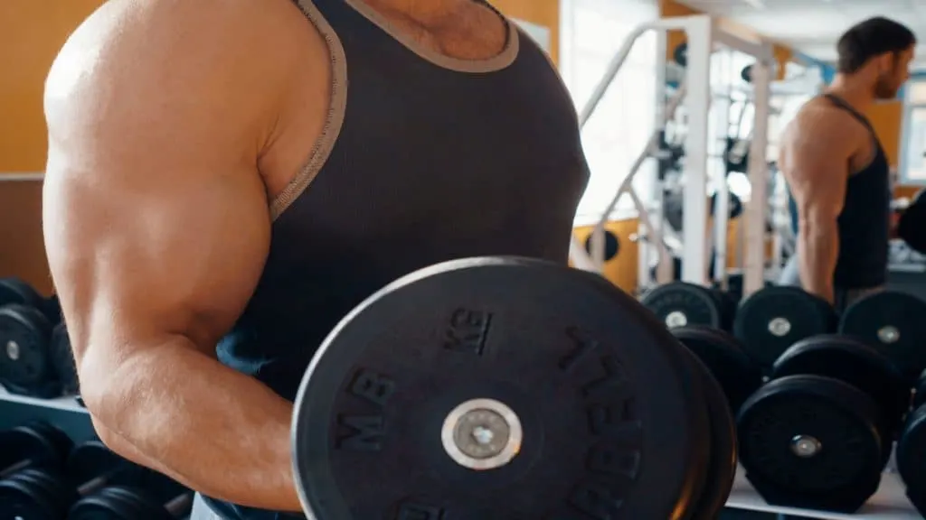 A man performing a 20 pound dumbbell curl to work his biceps