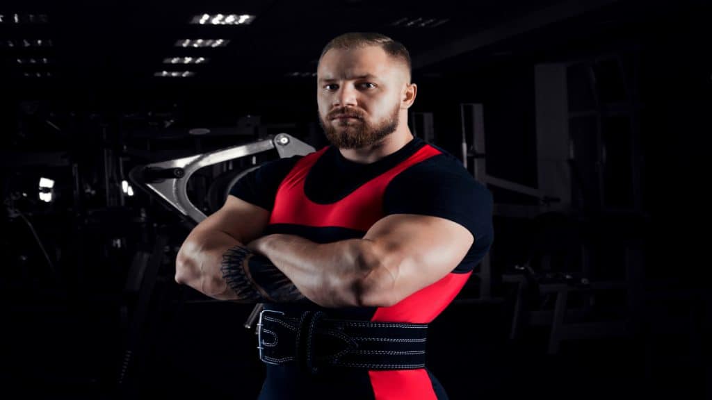 A powerlifter with 21 in biceps folding his arms