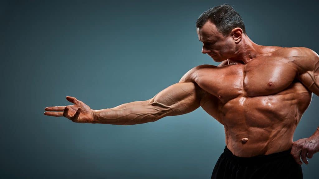 A bodybuilder posing his 23 inch bicep muscles