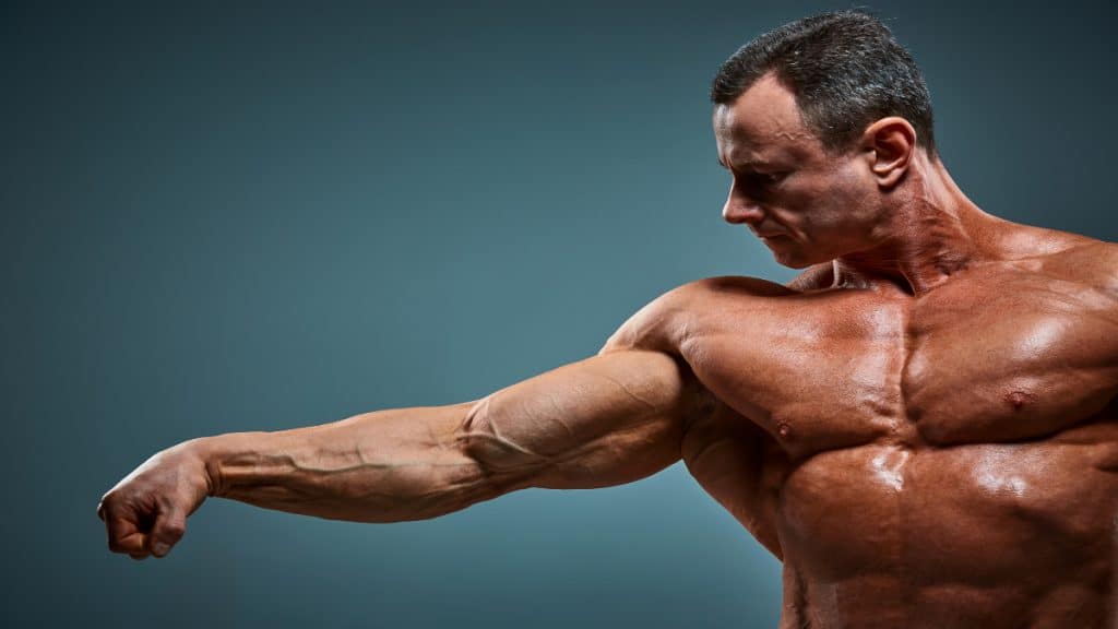A bodybuilder posing his 24 inch bicep muscles