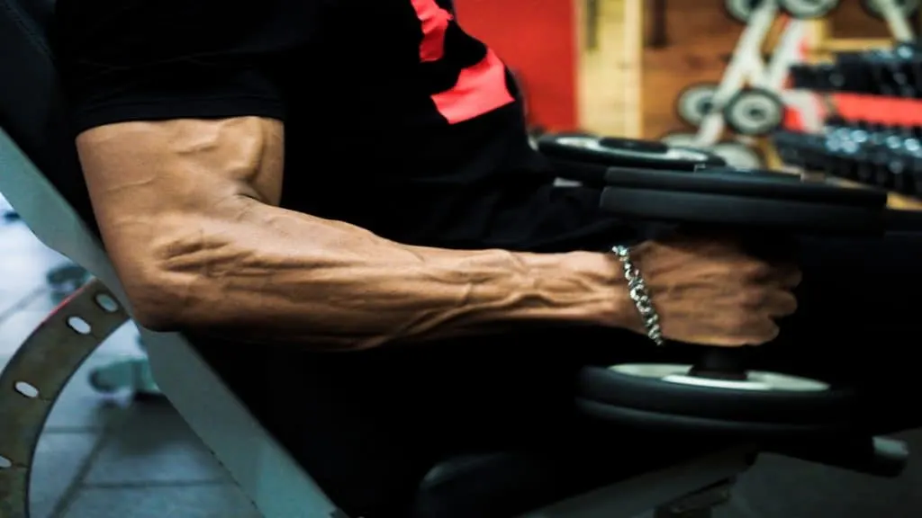 A muscular man doing 40 lb dumbbell curls for his biceps