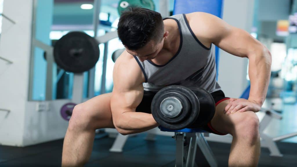 A man performing a 40 pound dumbbell curl at the gym