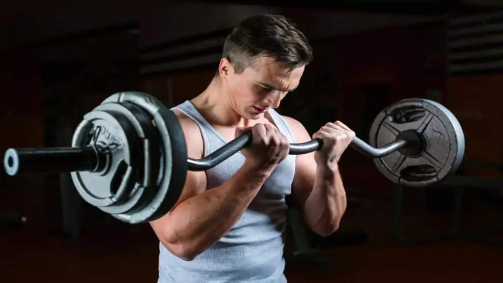 A man doing a 50 lb bicep curl with a barbell