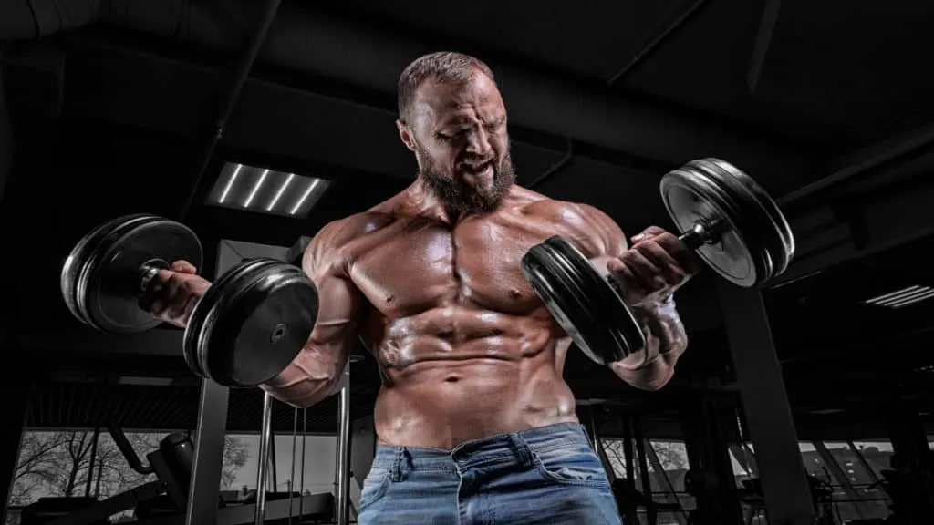 A bodybuilder performing 60 pound dumbbell curls