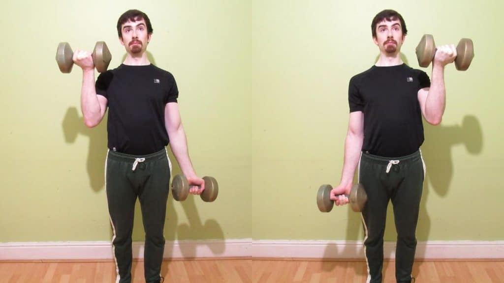 A man performing alternating dumbbell curls for his biceps