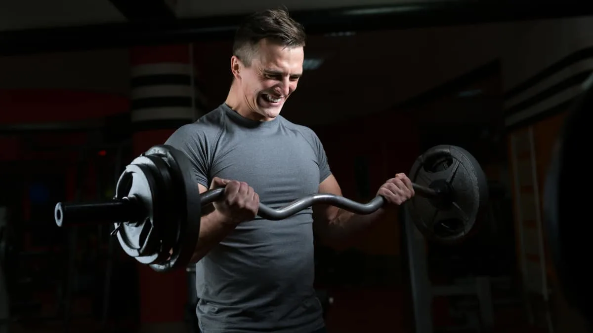 A man bicep curling 100 pounds with a barbell