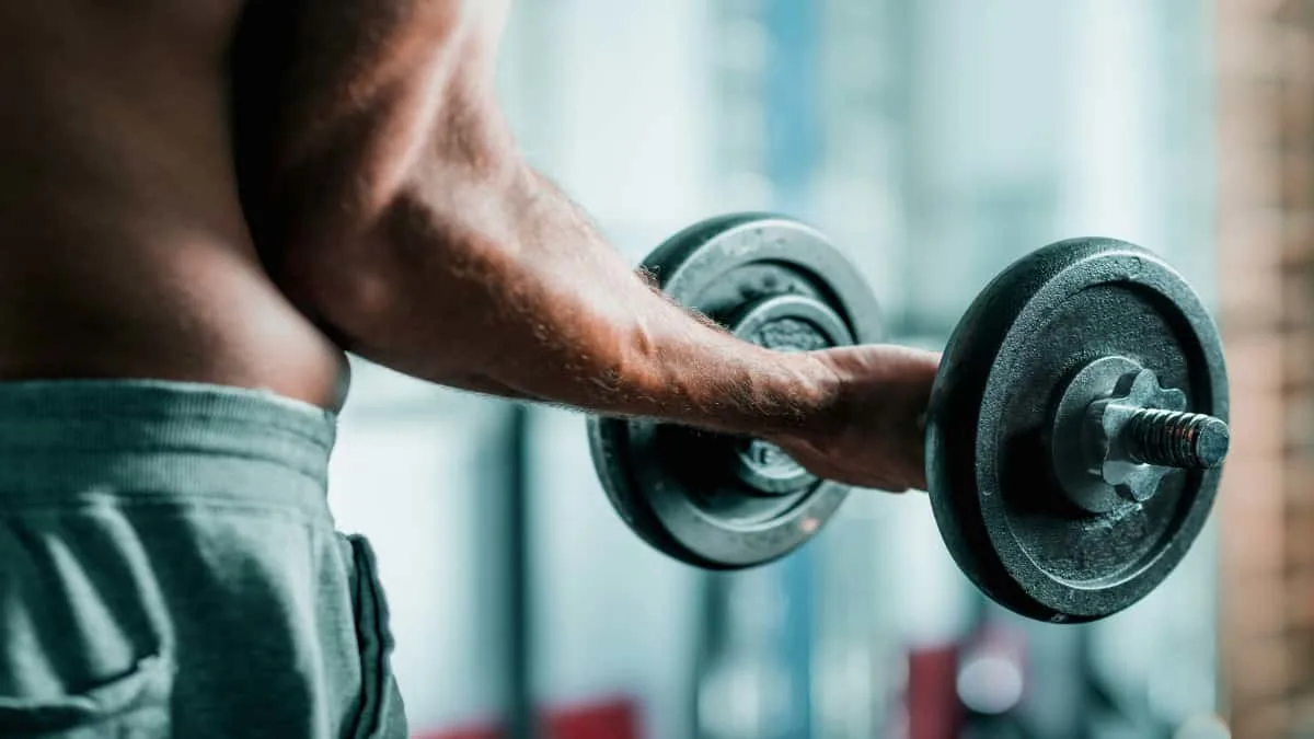 A man bicep curling 20 lb dumbbells at the gym