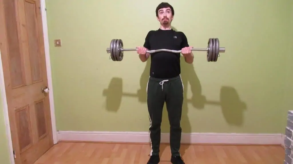 A man doing drag curls with an EZ bar