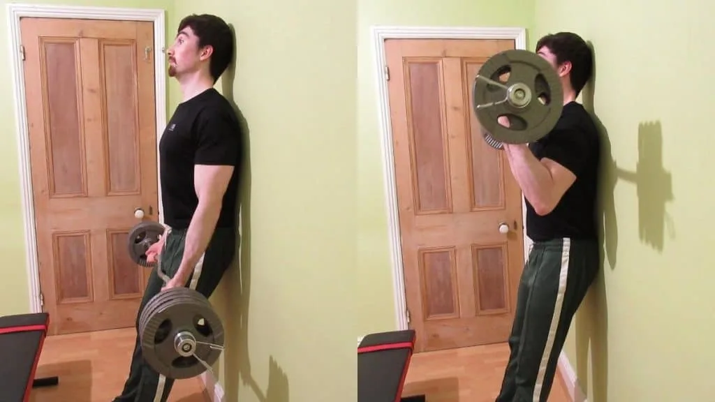 A man performing an EZ bar wall curl