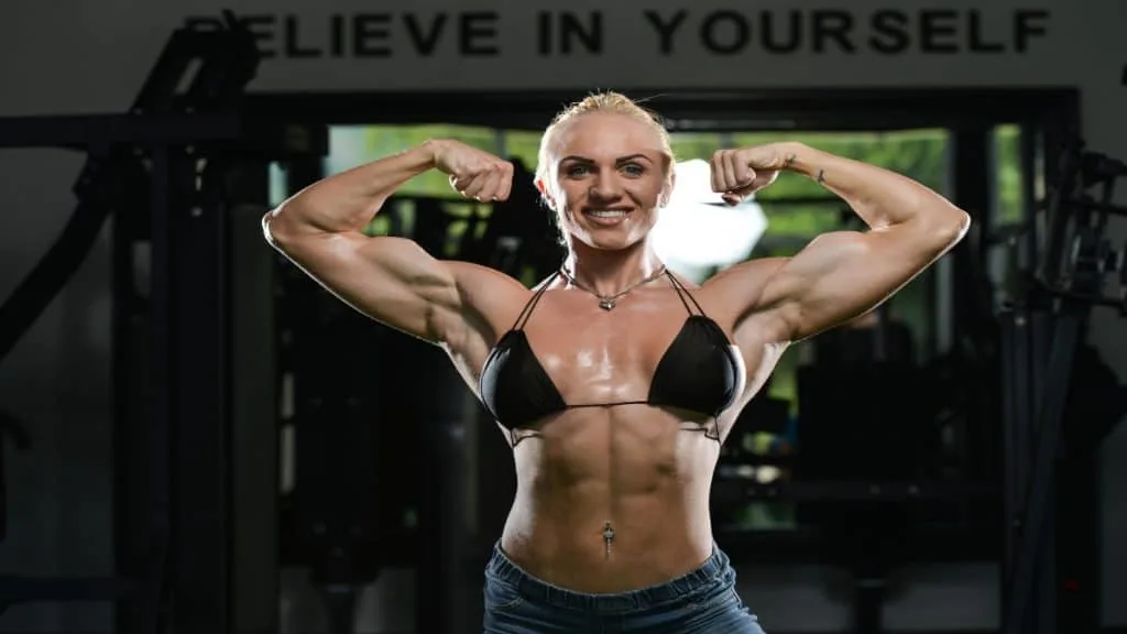 A female bodybuilder flexing her 18 inch biceps