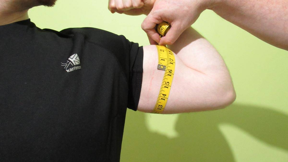 A man showing how to get 16 inch arms naturally