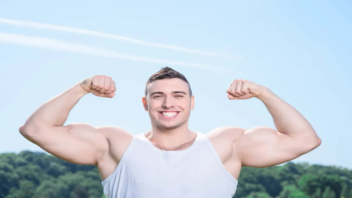 A man flexing his natural 18 inch arms