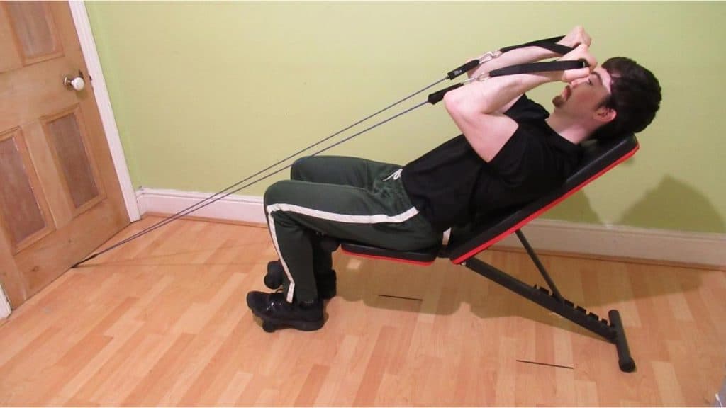 A man performing incline bench band curls