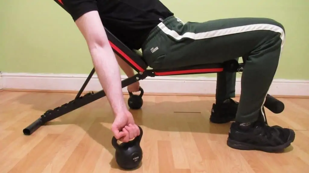 A man doing incline kettlebell curls