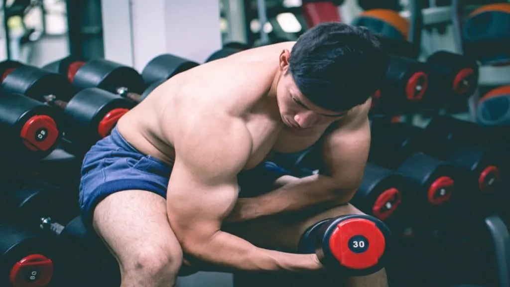 A man dumbbell curling 30 lbs with good technique