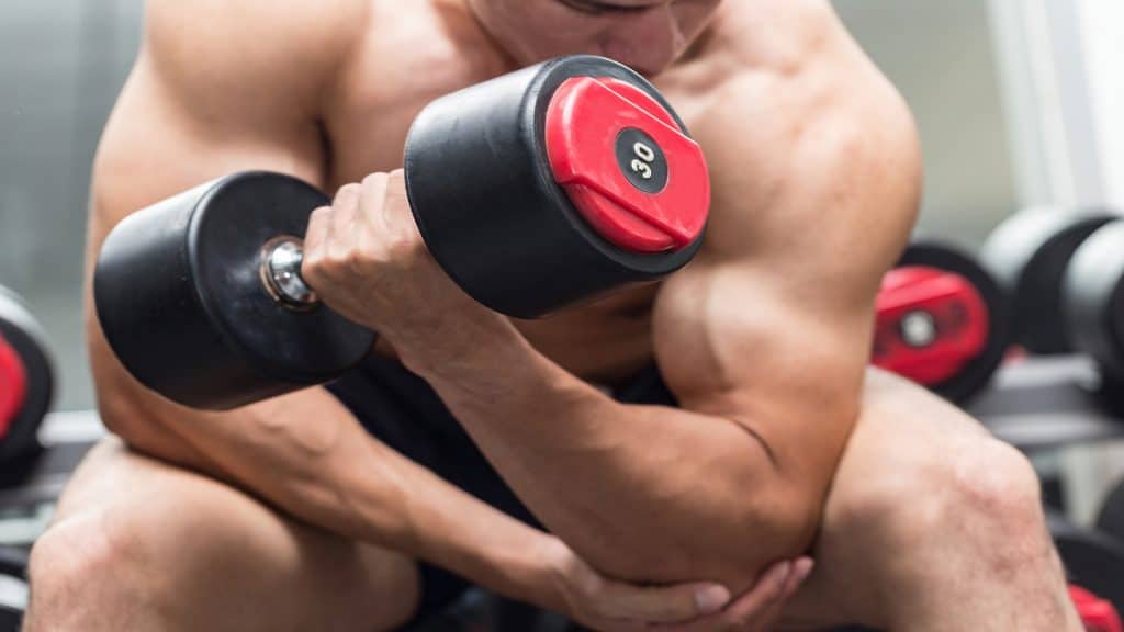 A man dumbbell curling 30 pounds with good form