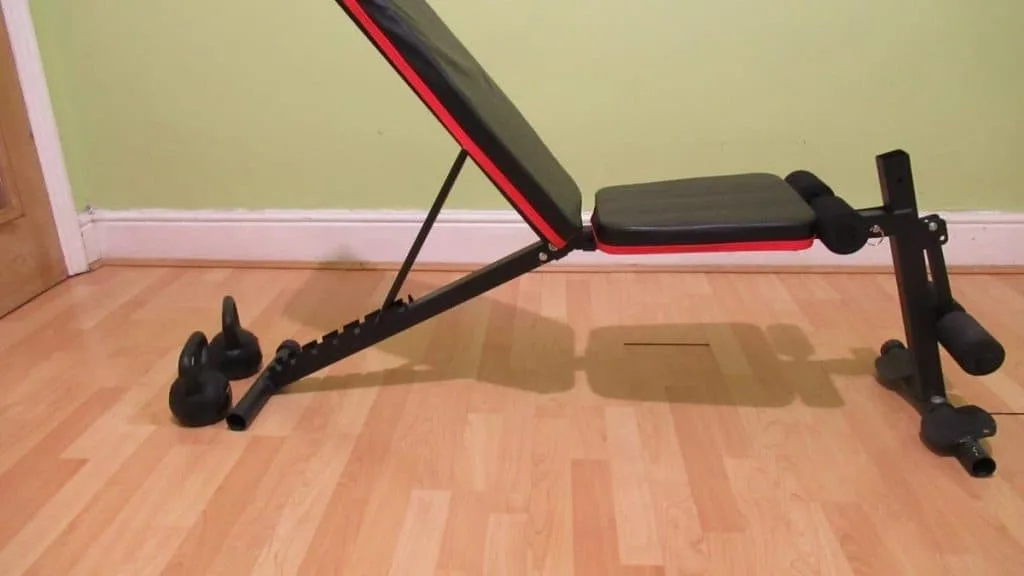 Kettlebells next to a bench; the setup for KB spider curls