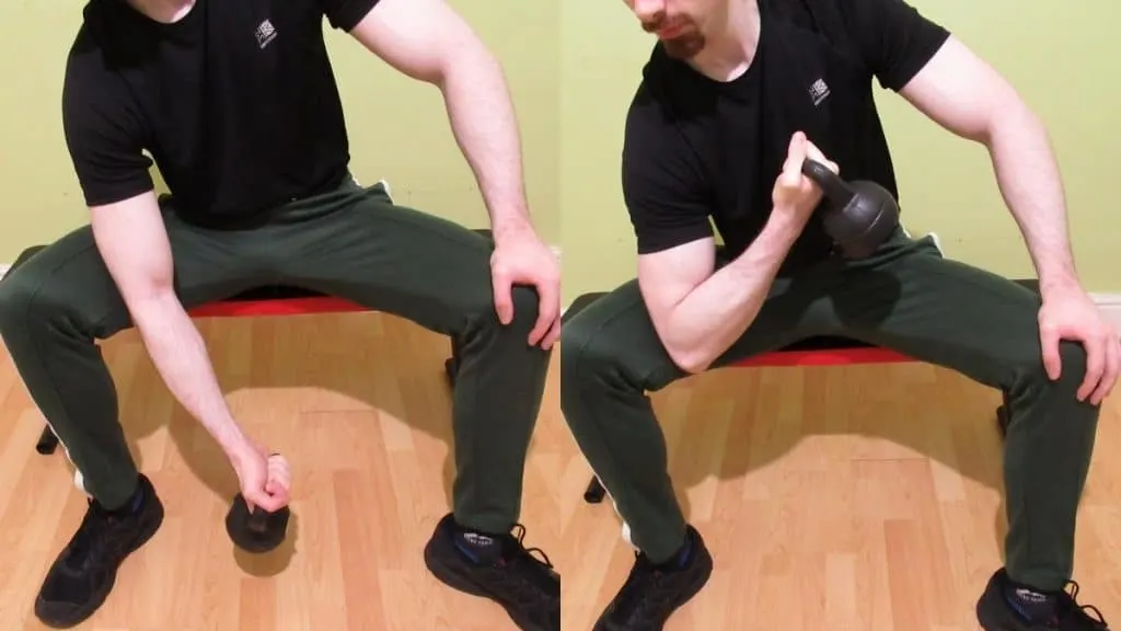 A man performing kettlebell concentration curls for his biceps