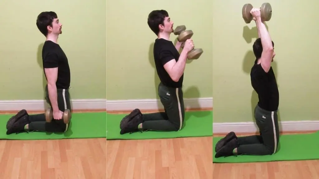 A man doing a kneeling bicep curl to overhead press